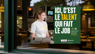 Devanture d'un restaurant McDonald's avec, en vitrine, l'affiche de la campagne Activateurs de progrès "Ici, c'est le talent qui fait le job", déclinée aux couleurs McDonald's.