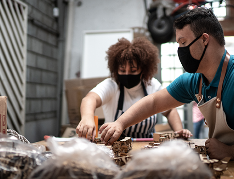 Photo d'une personne en situation de handicap qui travaille avec des jouets en bois