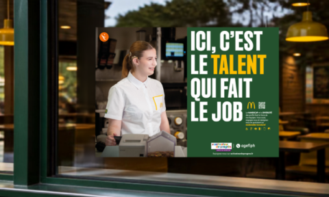 Devanture d'un restaurant McDonald's avec, en vitrine, l'affiche de la campagne Activateurs de progrès "Ici, c'est le talent qui fait le job", déclinée aux couleurs McDonald's.